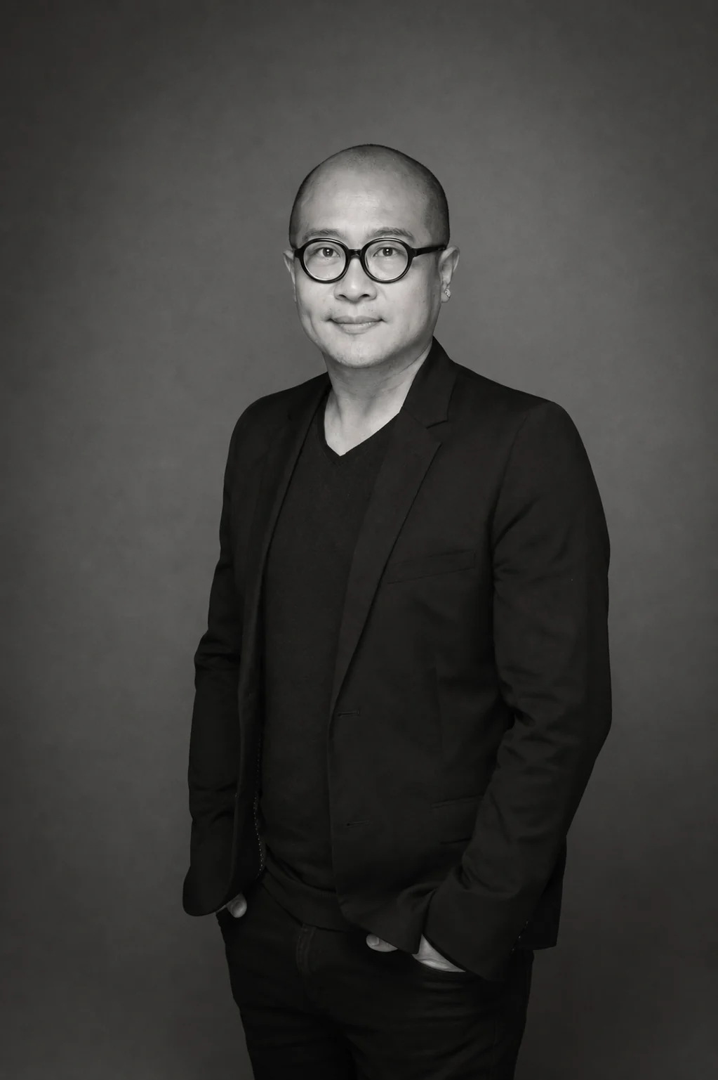 Black-and-white full-length studio portrait of Hong Kong photographer Chris Chan